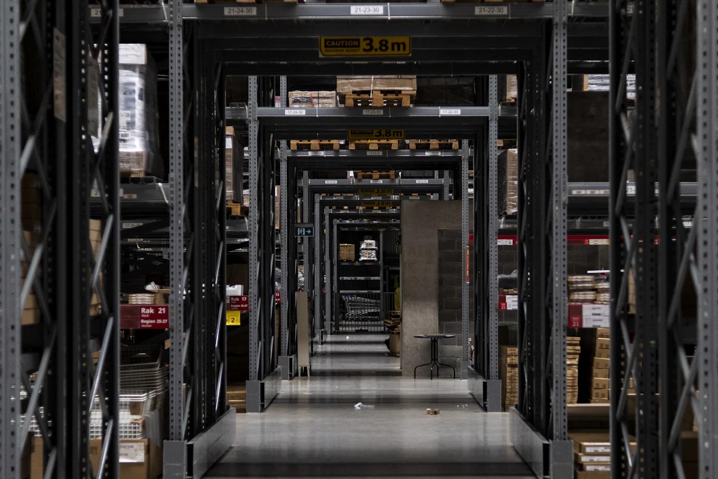 Organized warehouse aisle stacked with cardboard parcels — the kind of fulfillment infrastructure behind every N-Verse order